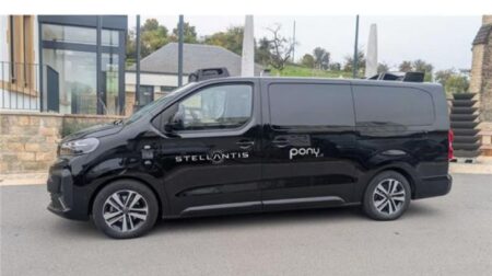A black Peugeot e-Traveller van parked on a city street with PonyAI and Stellantis written down the side