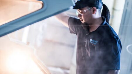 A mechanic lifting the hood of a vehicle.