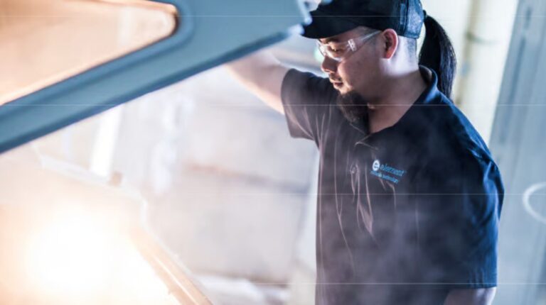 A mechanic lifting the hood of a vehicle.